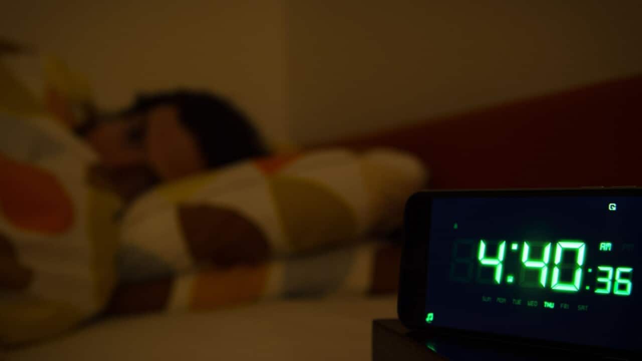 A man awake in bed in the early hours of the morning