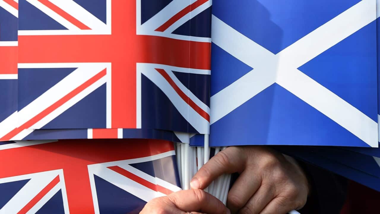 A Unionist holds the Union jack (L) and the Saltire flag