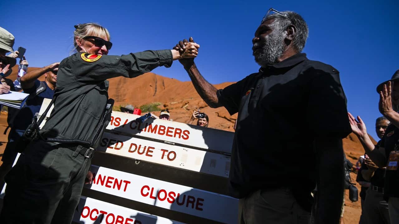 Ranger Lynda Wright and Chair of the Uluru-Kata Tjuta Council Sidney James shake hands as the climbing ban is imposed