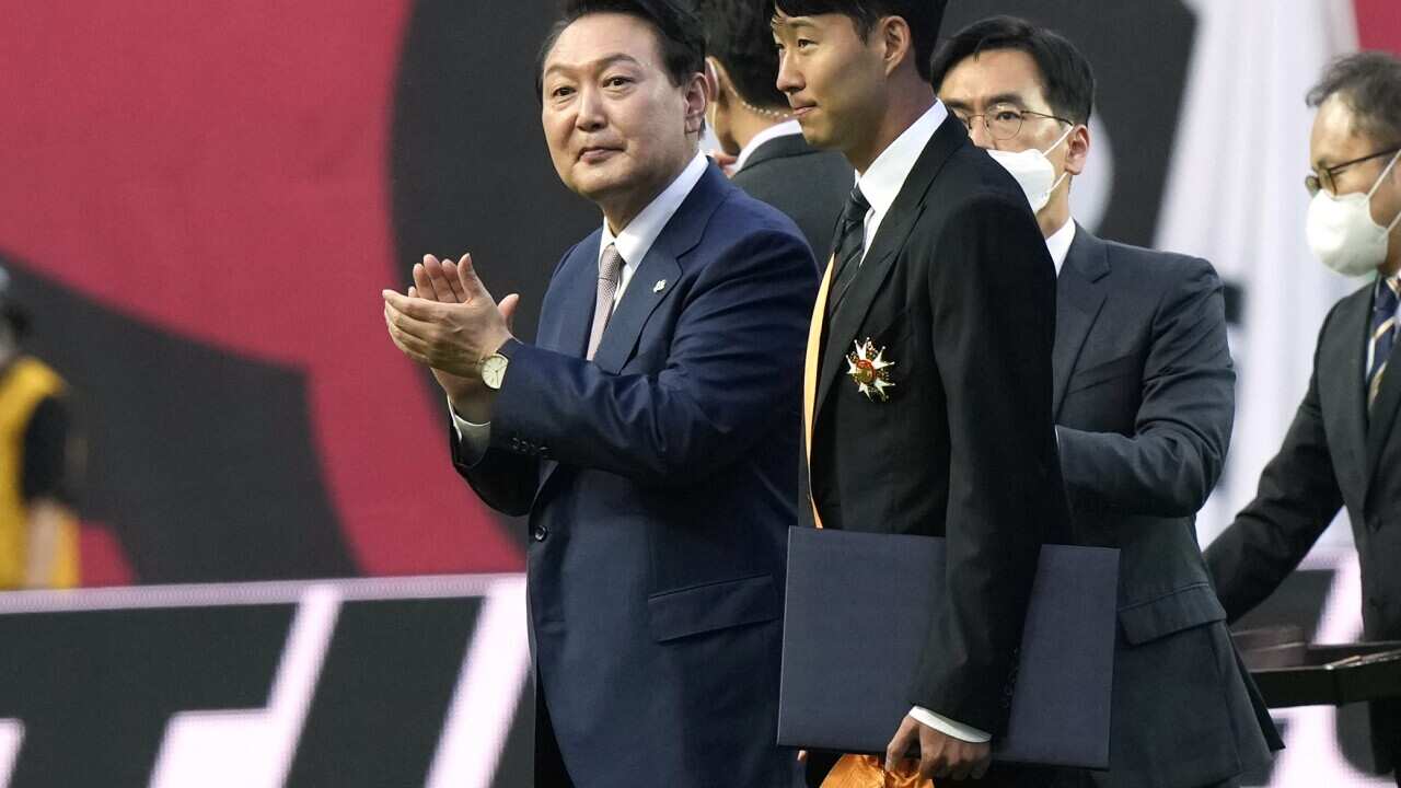 Tottenham Hotspur's South Korean forward Son Heung-min, center, is congratulated by South Korean President Yoon Suk Yeol (AP Photo/Ahn Young-joon)