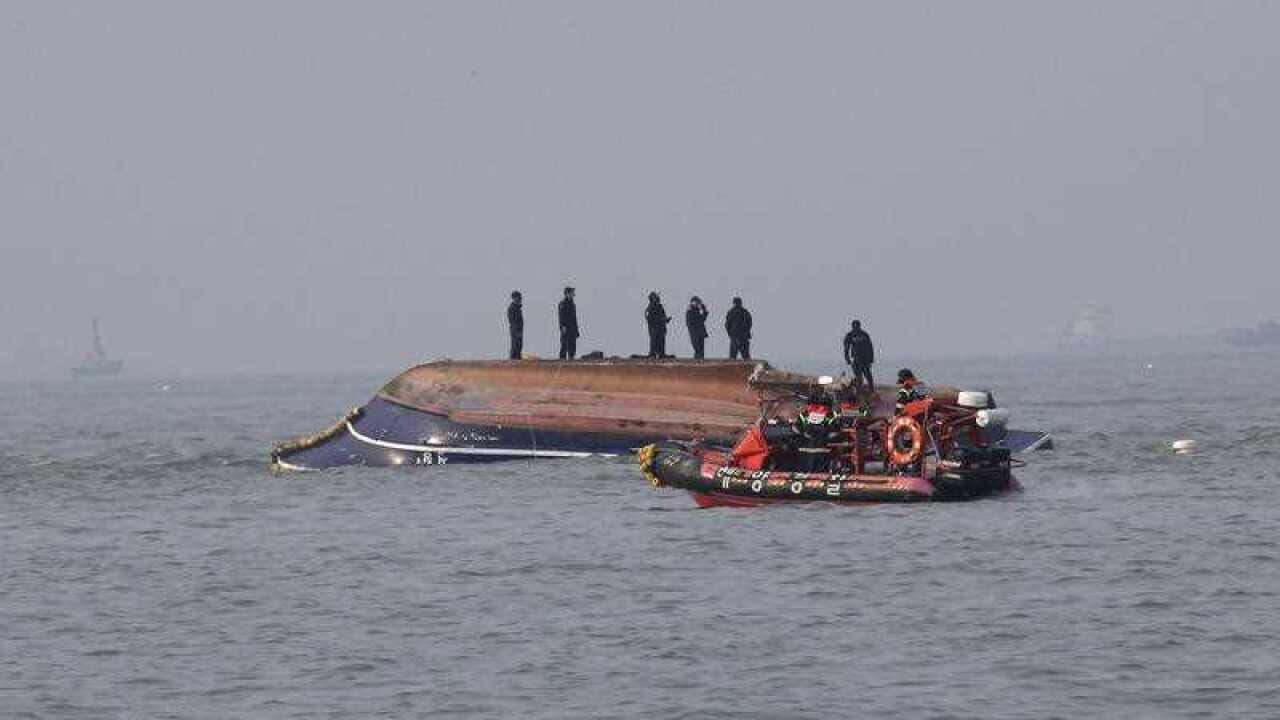 South Korean Coast Guard officers try to rescue a capsized fishing boat which collided with a refuelling vessel in the waters off Incheon, South Korea.