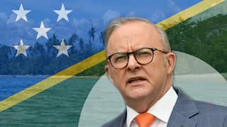 Anthony Albanese pictured against the Solomon Islands flag