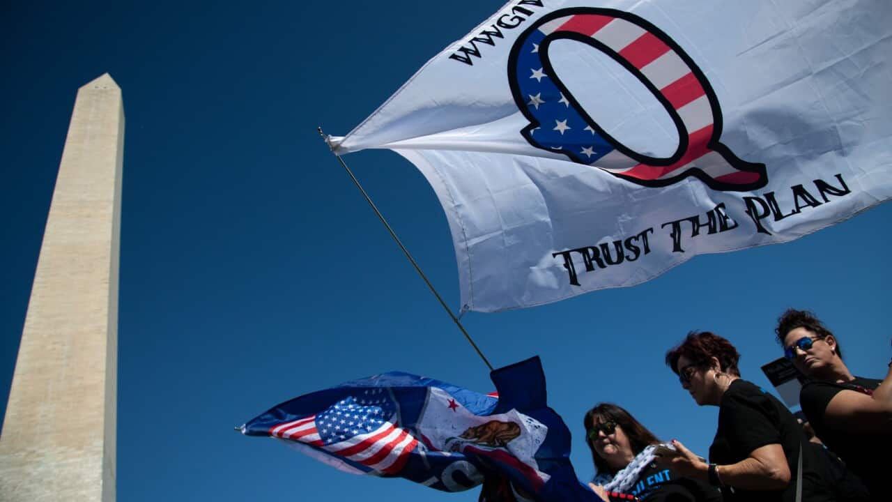 A protester waves a QAnon flag near the Washington Monument, as part of the Unsilent March, on October 3, 2020.