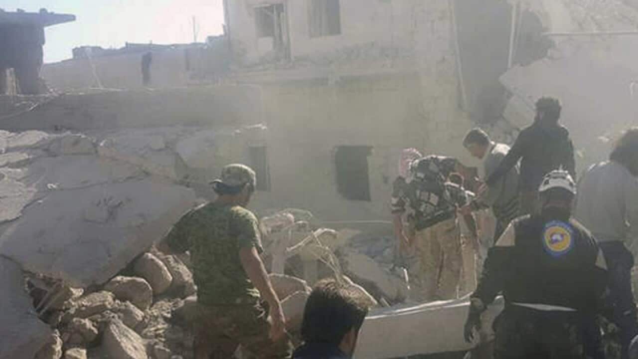 Civil Defense workers inspecting damaged after in Darat Izza town