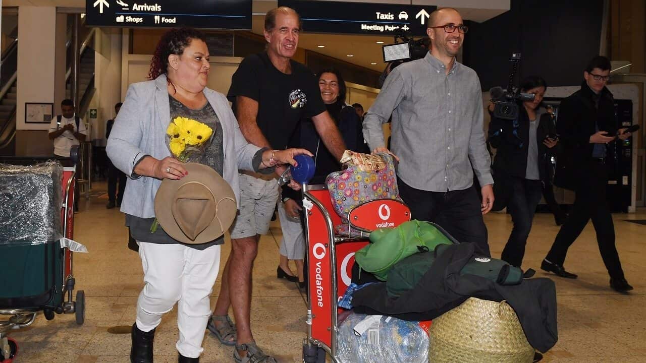 Australian filmmaker James Ricketson (centre) with his daughter Roxanne Holmes (left) arrives at Sydney International Airport.
