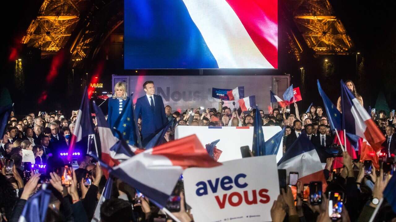 epa09907879 French President Emmanuel Macron and his wife Brigitte Macron celebrate on the stage at the Champs-de-Mars after Emmanuel Macron won the second round of the French presidential elections in Paris, France, 24 April 2022 (issued 25 April 2022).