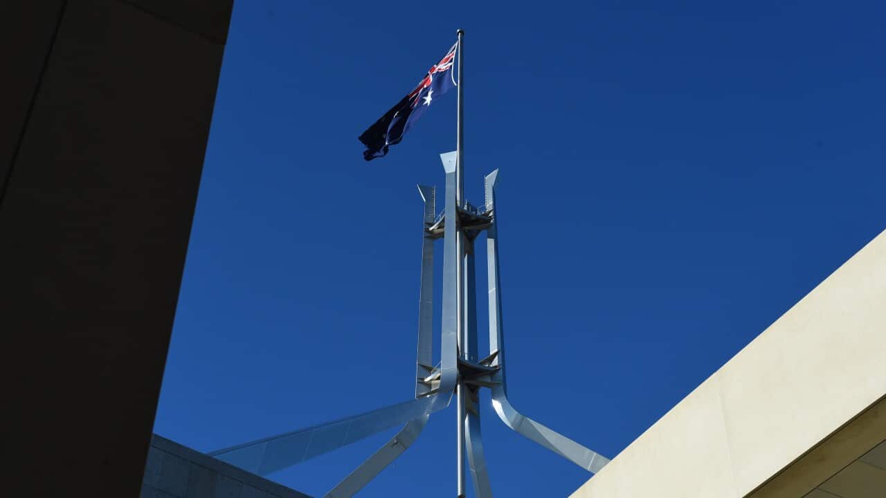 The Australian flag is seen above Parliament House in Canberra.