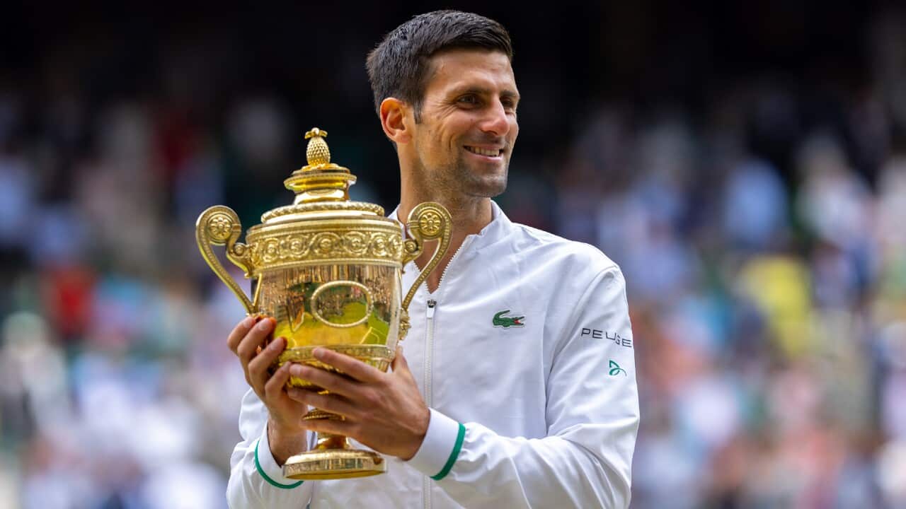 Novak Djokovic celebrates with the Wimbledon Championship trophy