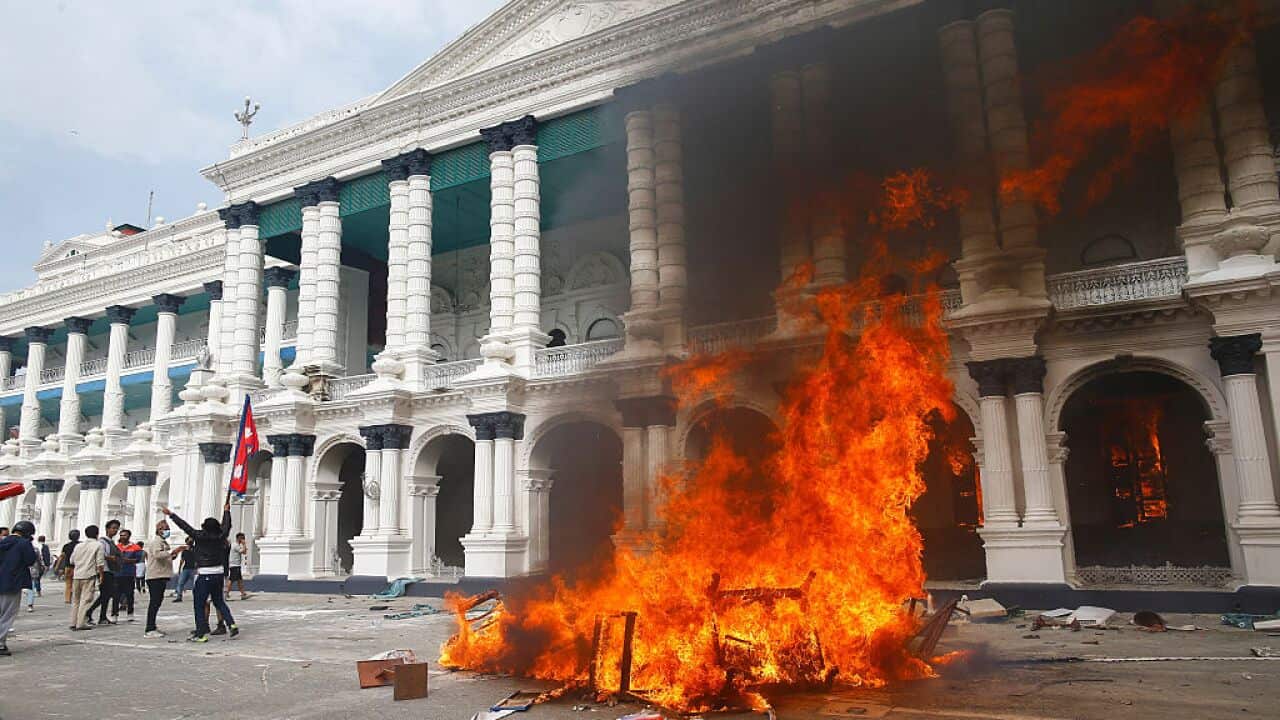 Fire and protests in front of a government building.