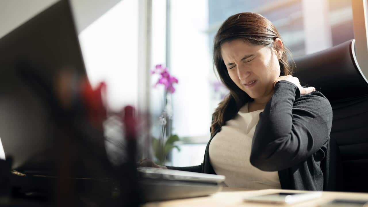 Tired businesswoman holding her nape