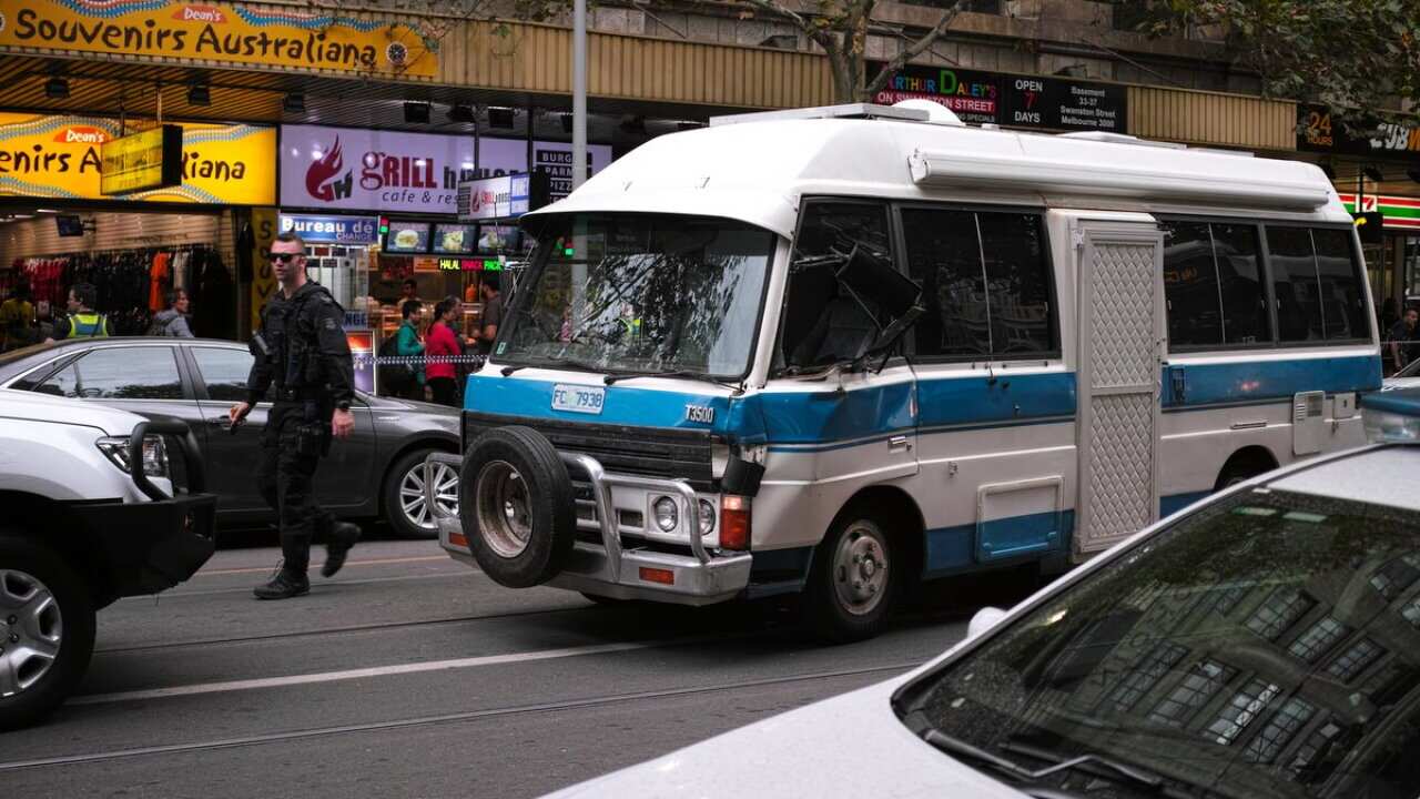 A blue and white minibus has been driven the wrong way along Swanston Street