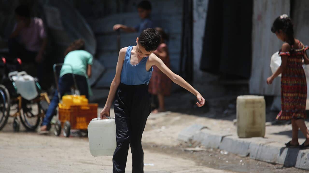 A child carrying a drum of water.