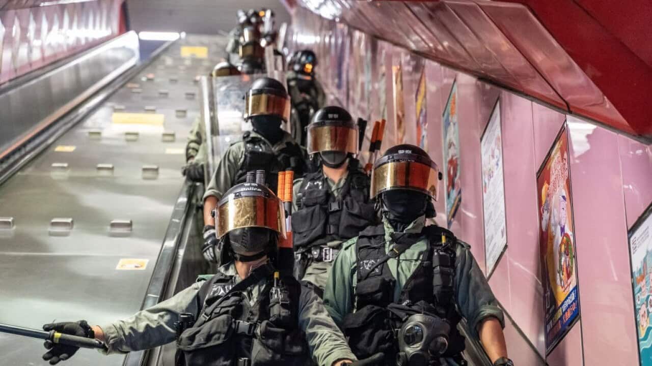 Riot police charge inside the Tai Koo MTR station in Hong Kong, China.