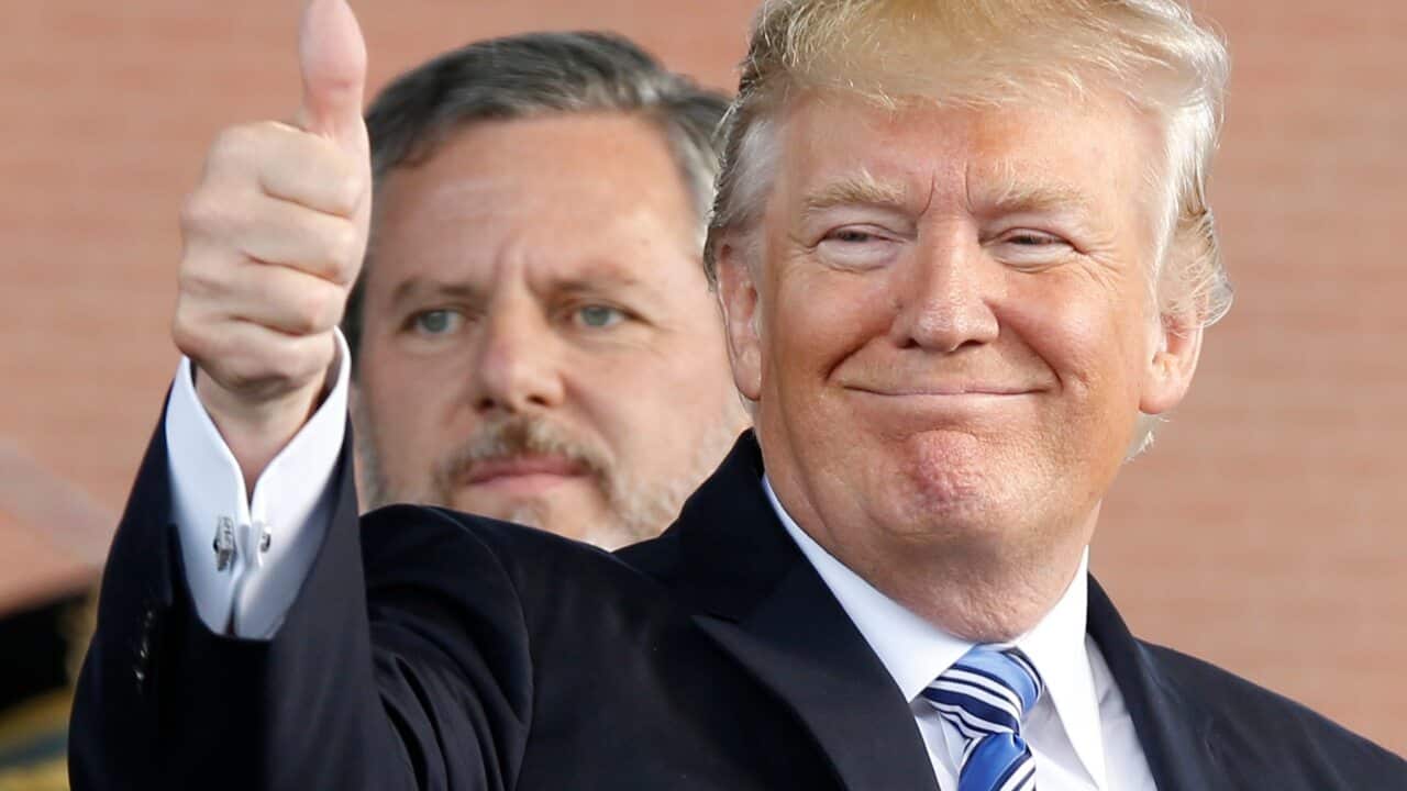 President Donald Trump, right, gives a thumbs up as Liberty University president, Jerry Falwell Jr., left, watches.