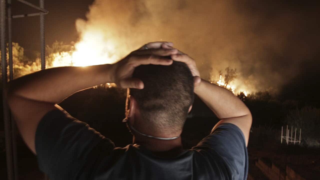 A man looks at a forest fire near the village of Larbaa Nath Irathen in Algeria, Wednesday, Aug.11, 2021.