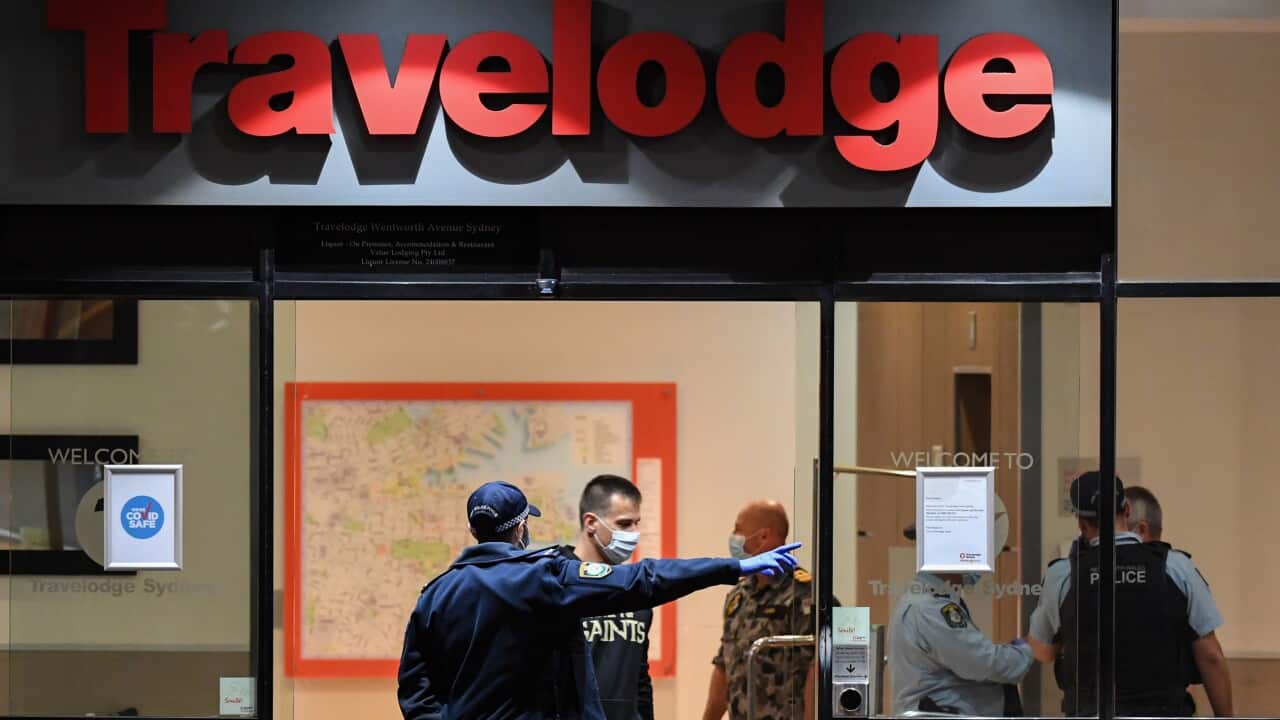 Guests under police guard depart the Travelodge Hotel in Surry Hills on 25 August, 2020 in Sydney.