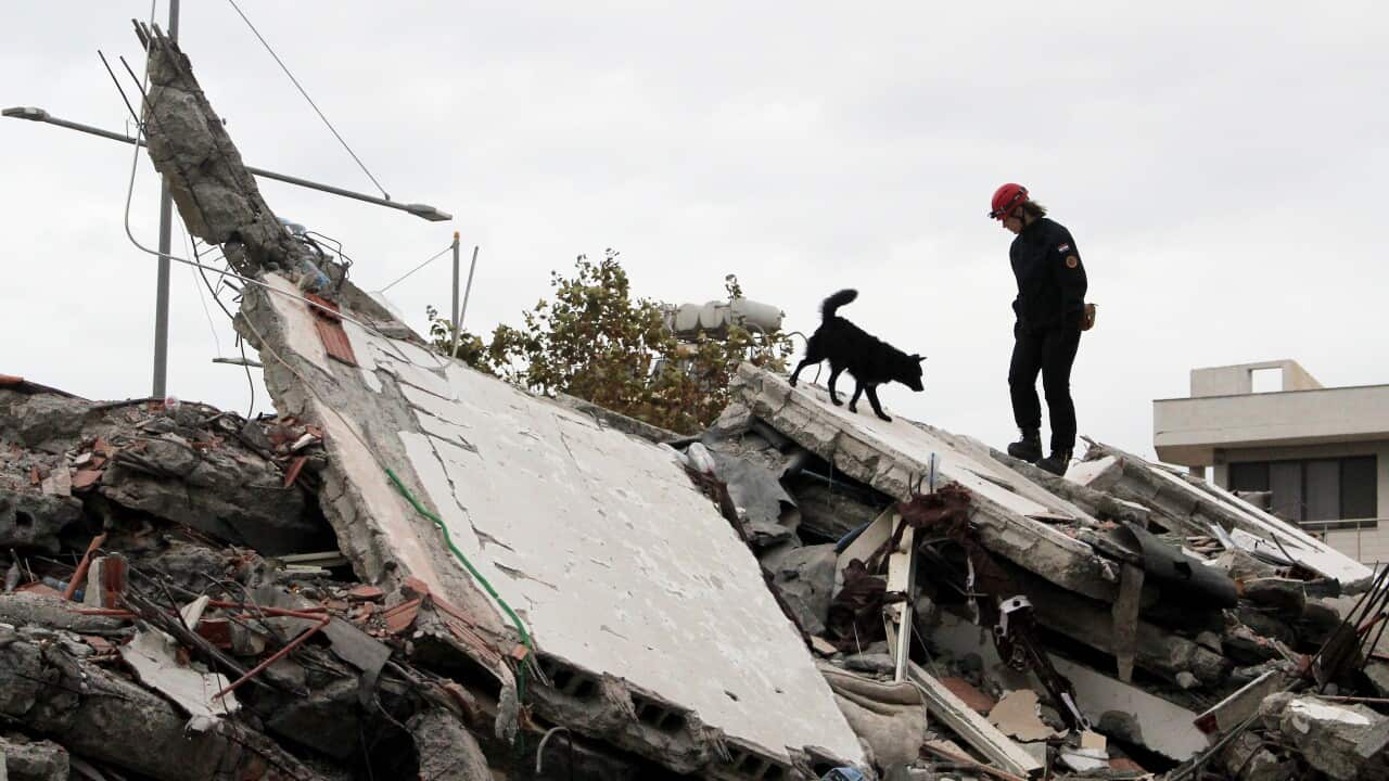 A search and rescue team member searches in the rubble of a building after an earthquake hit Durres, Albania.