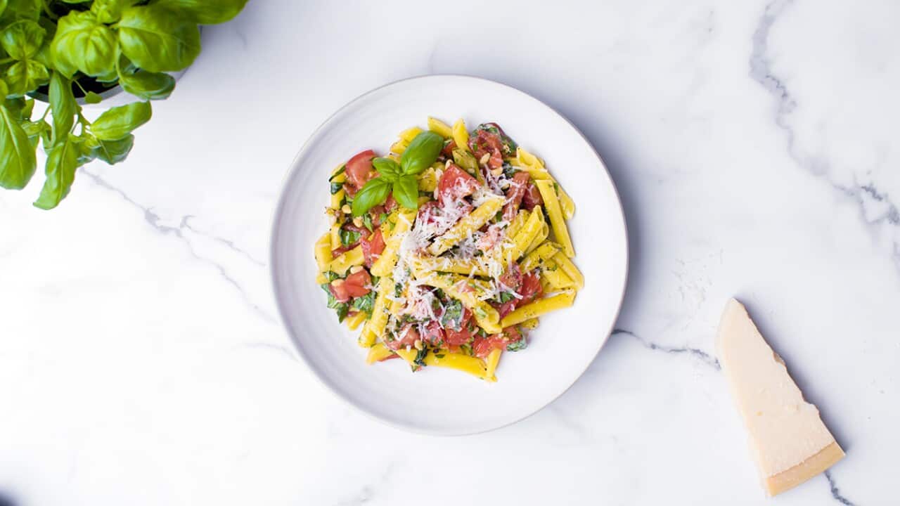 Chopping board tomato and basil pesto pasta