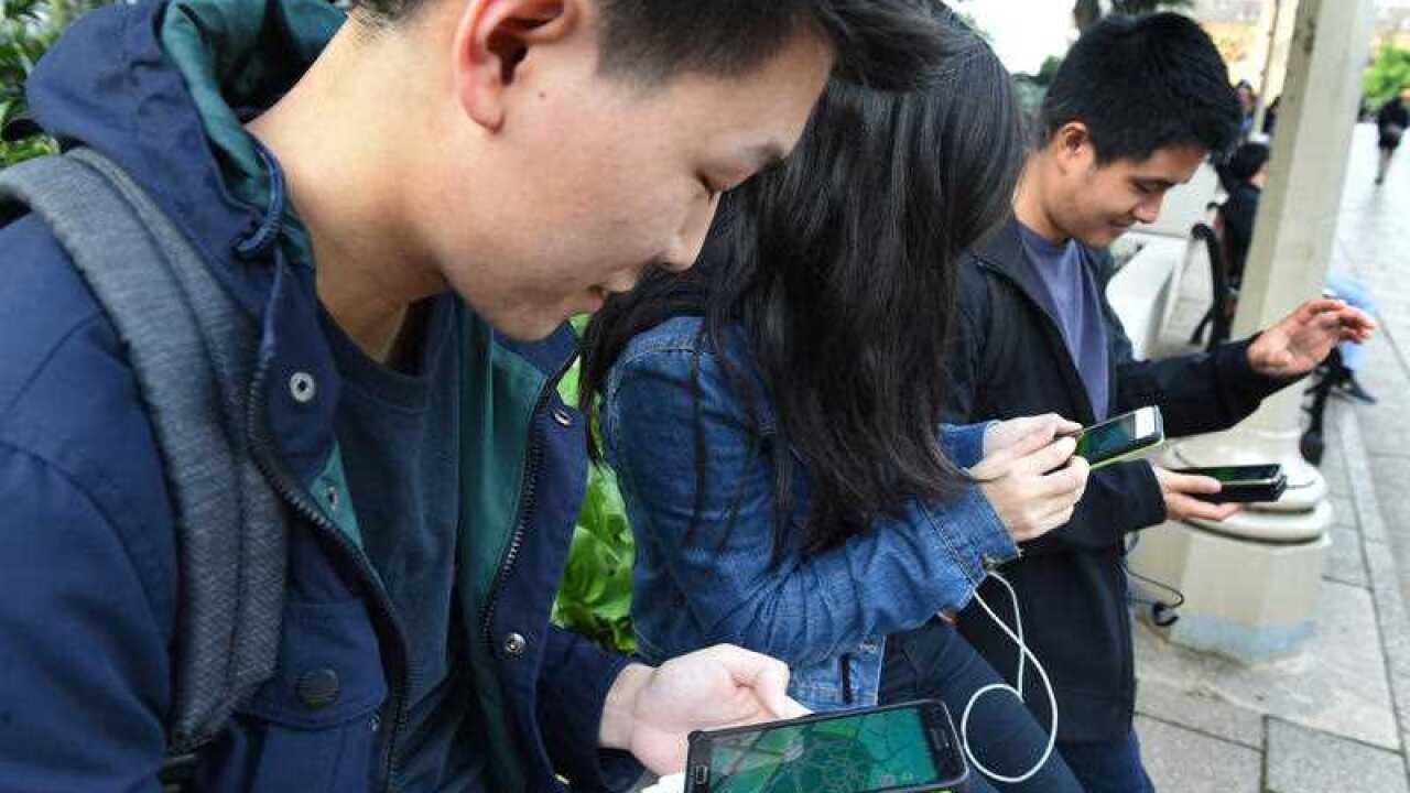Pokemon Go being played by young people in Hyde Park in Sydney