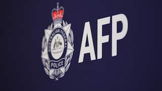 Australian Federal Police logo and the letters “AFP” displayed in white on a dark blue backdrop.