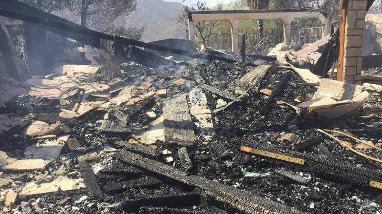 The remains of a burned home smoulder in Iron Canyon Road area near Santa Clarita, California