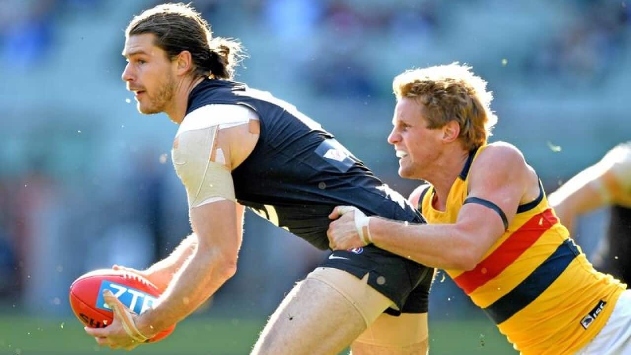Bryce Gibbs of the Blues is tackled