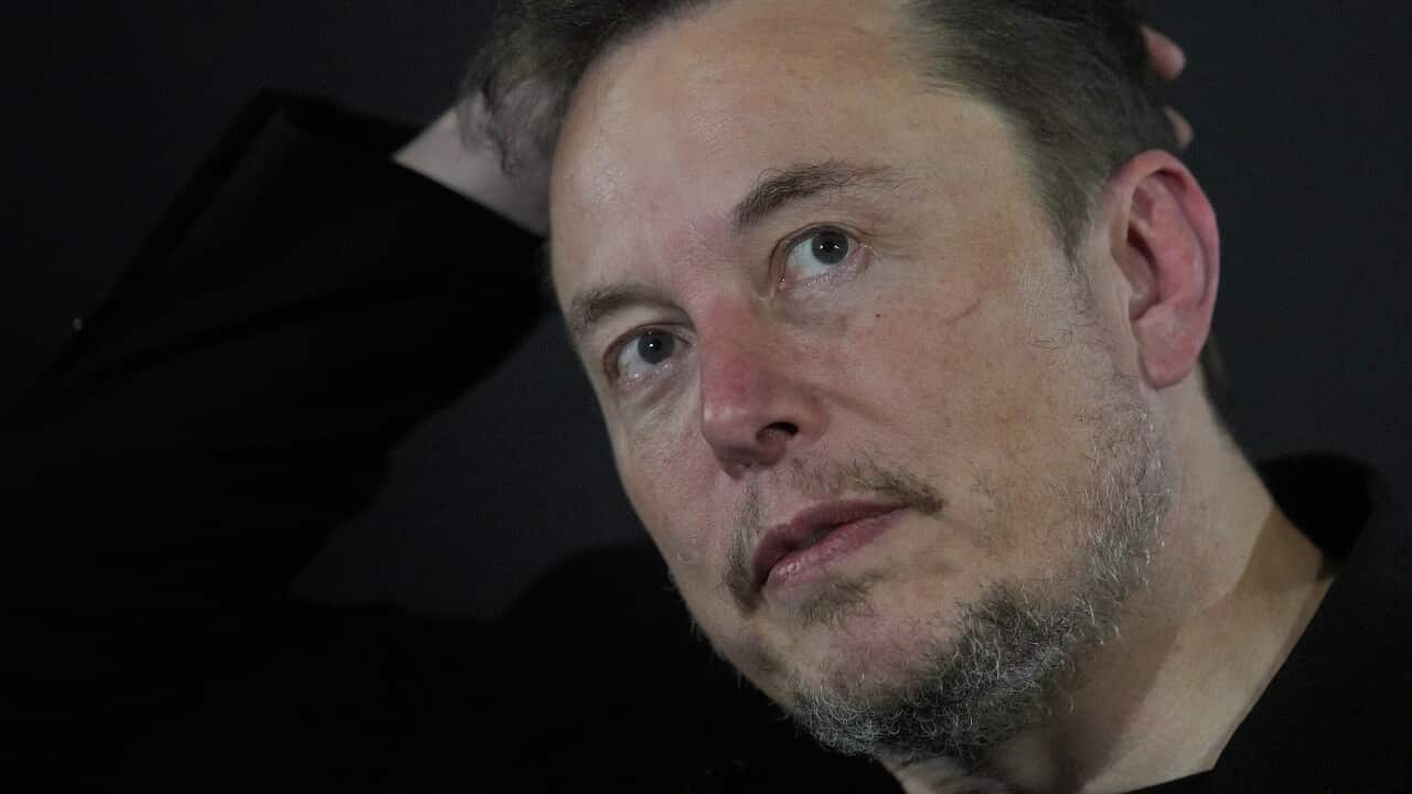 A close up of a man's face, with his hand behind his head.