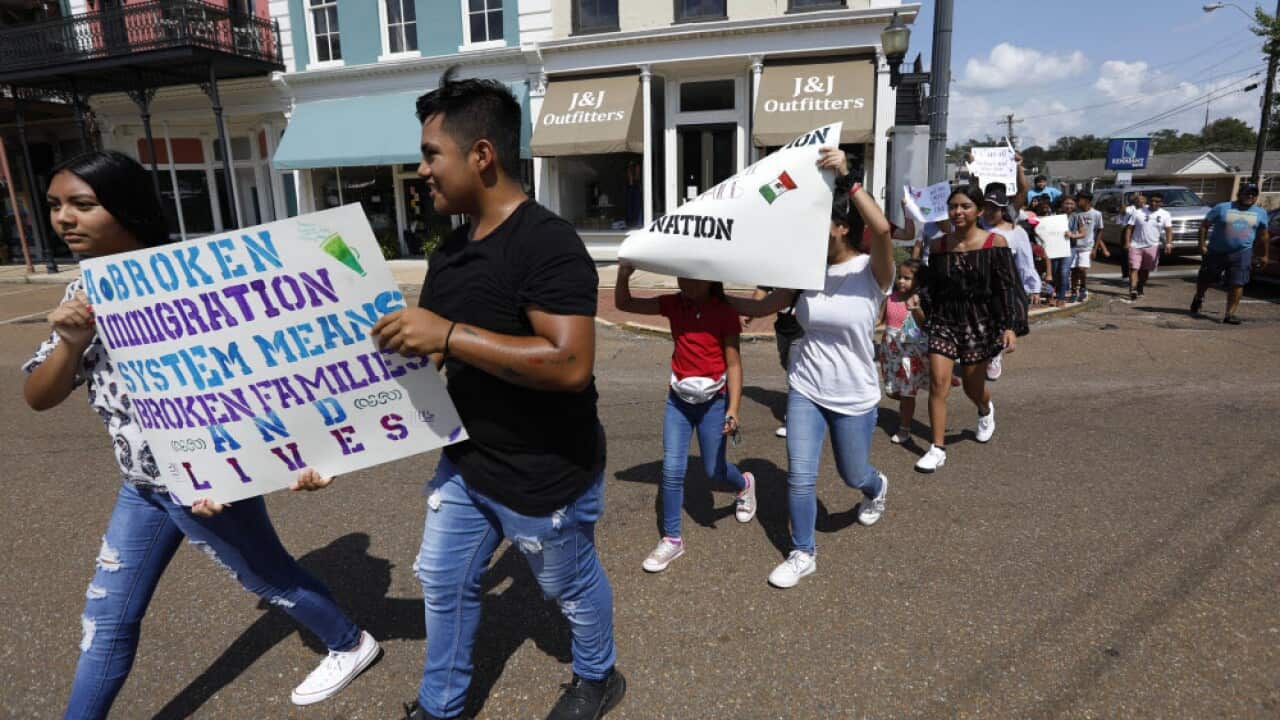 Children of mainly Latino immigrant parents hold signs in support of them and others picked up during an immigration raid at a food processing plant