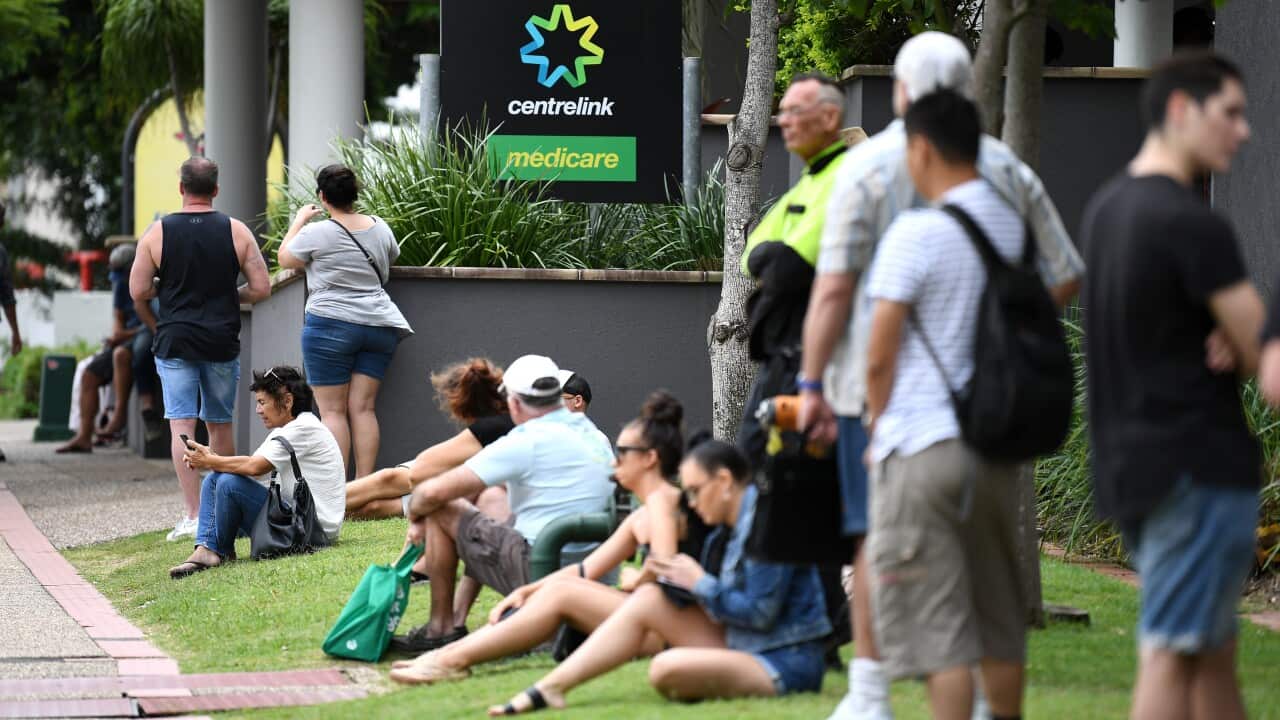 People are seen in long queues outside the Centrelink office in Southport on the Gold Coast, Monday, March 23, 2020.