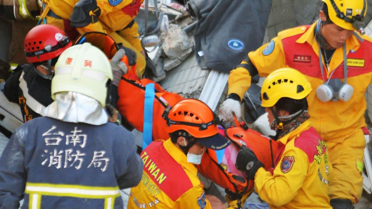 An 8-year-old girl (C) is rescued from the rubble of an apartment complex in Tainan, southern Taiwan, on Feb. 8, 2016, about 60 hours after the complex collapsed due to a magnitude 6.4 earthquake.