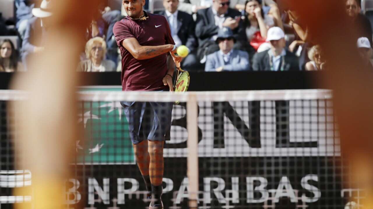 Nick Kyrgios of Australia returns the ball to Rafael Nadal of Spain