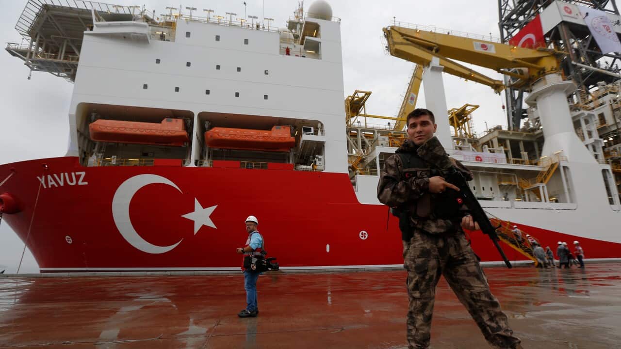 Thursday, June 20, 2019 file photo, a Turkish police officer patrols the dock, backdropped by the drilling ship 'Yavuz'