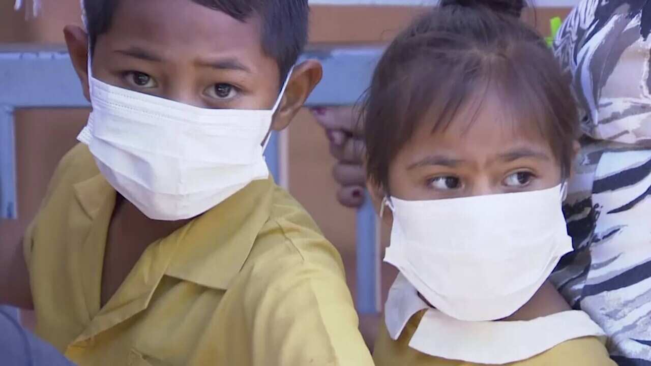 Masked children wait to get vaccinated at a health clinic in Apia, Samoa.