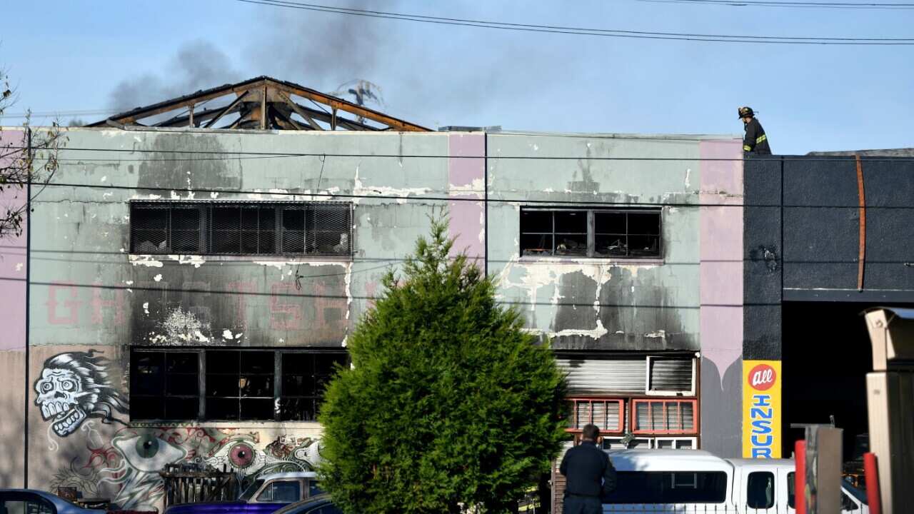 Firefighters work at the aftermath of a warehouse fire in the Fruitvale district of Oakland at the corner of 31st (AAP)