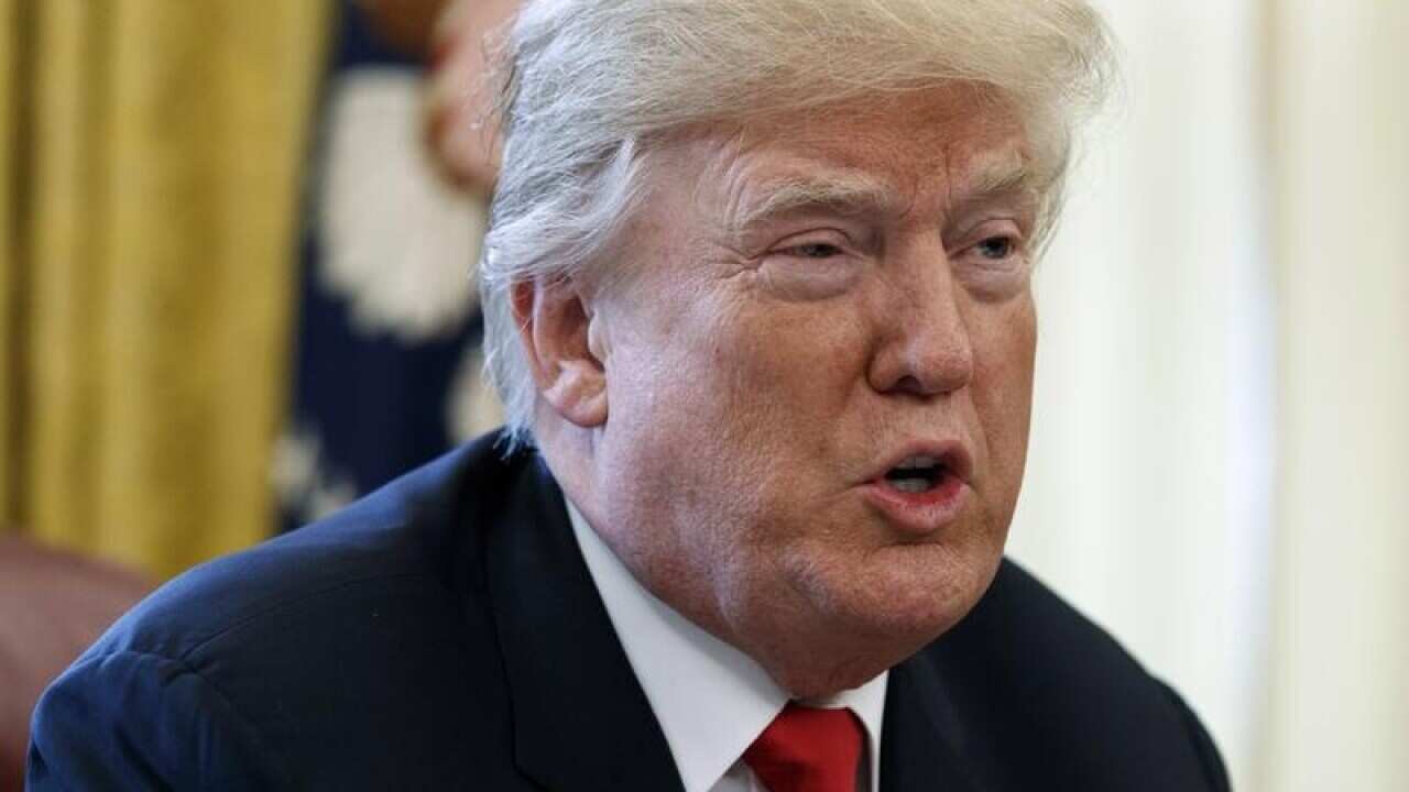 President Donald Trump speaks with reporters in the Oval Office.