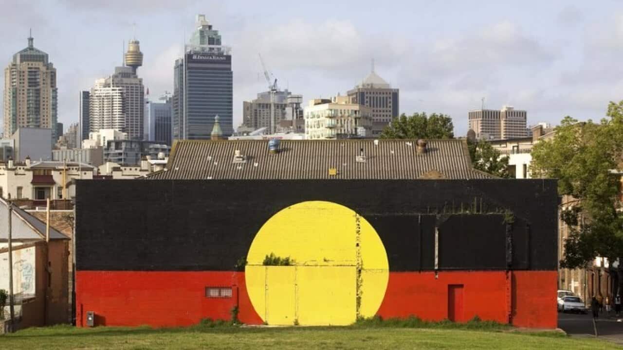 An Aboriginal flag mural is pictured in front of the Sydney skyline in Redfern, Sydney, Australia, 2008.