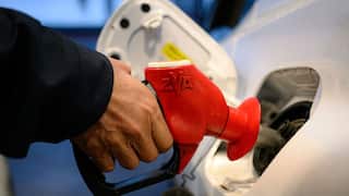 A hand holding a petrol pump