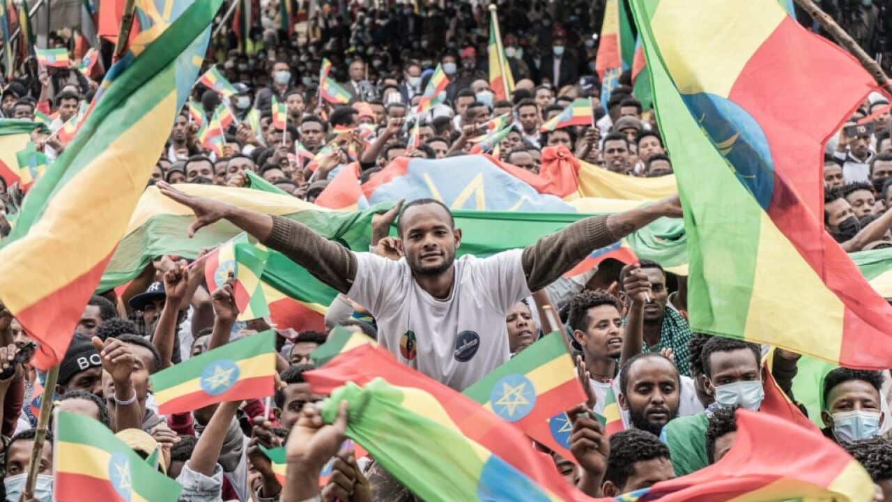 Members of the military wave the Ethiopian flag during a farewell ceremony for new recruits joining the Ethiopian military to Tigray, 27 July, 2021.
