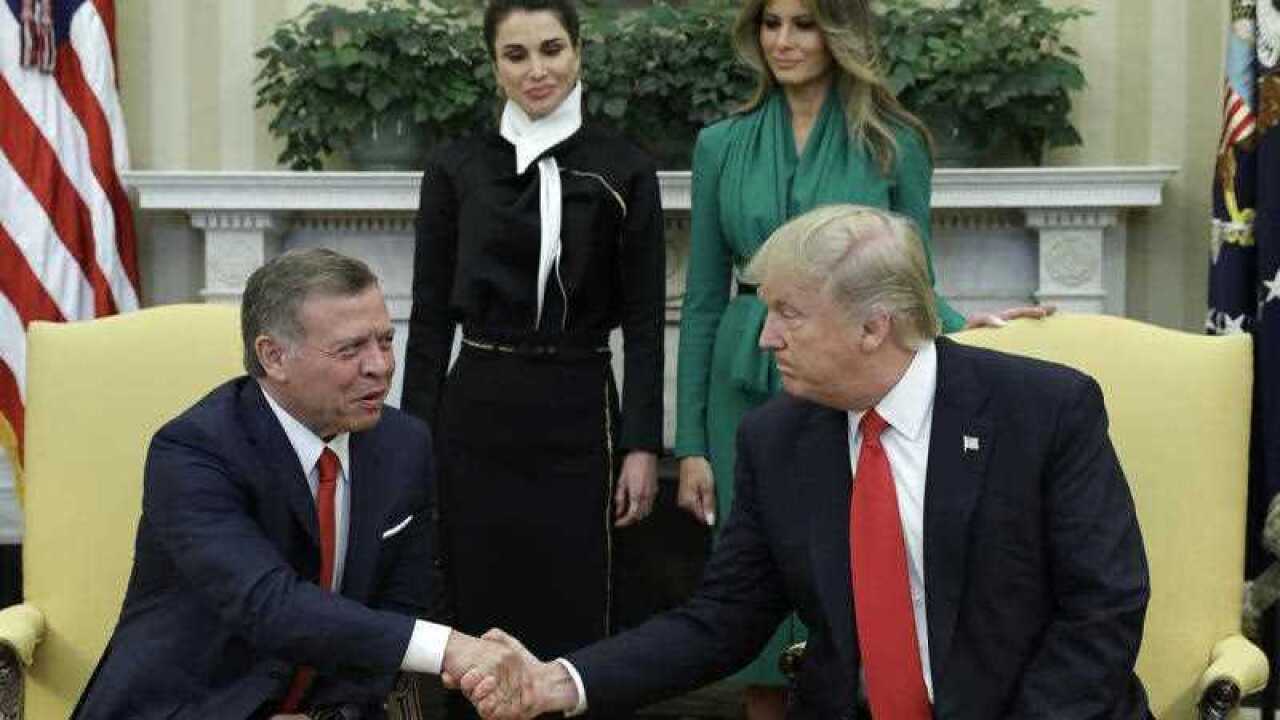 President Donald Trump, accompanied by first lady Melania Trump and Queen Rania, shakes hands with Jordan's King Abdullah II in the Oval Office of the White House in Washington.