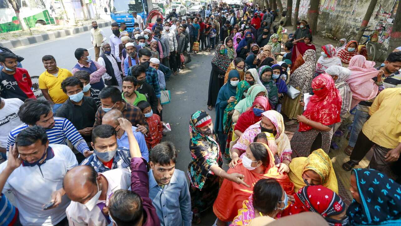 Bangladeshi people wait in a queue to buy essentials from Trading Corporation of Bangladesh. 16 February, 2022.