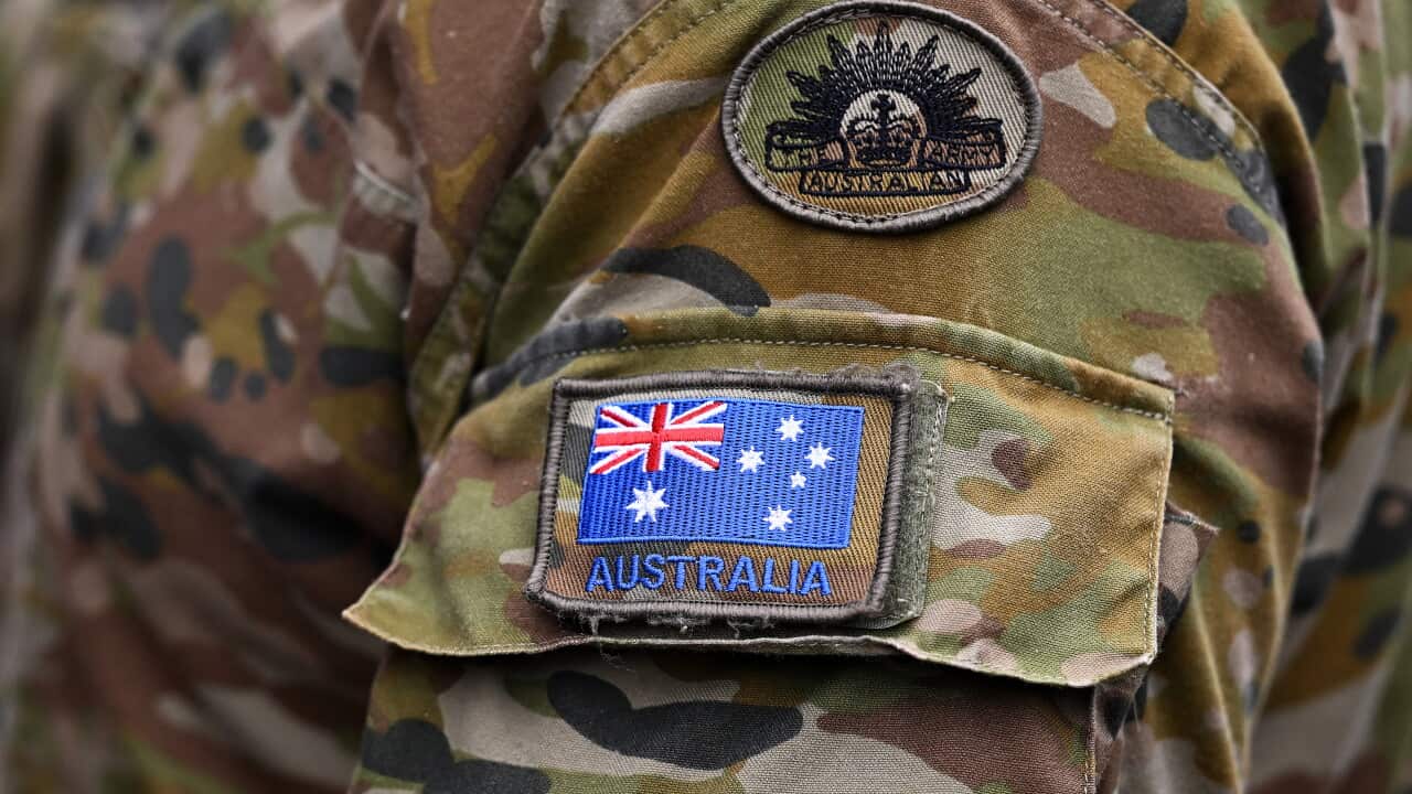 Australian flag and Australian Army patches sewn onto a camouflage print military uniform.