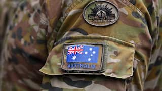 Australian flag and Australian Army patches sewn onto a camouflage print military uniform.