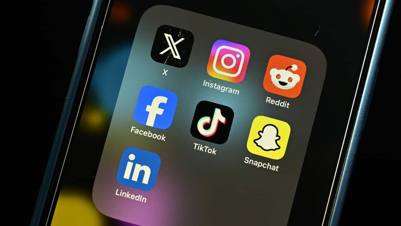 A close-up image of an iPhone with several social media app icons collected in a folder titled 'social media'.