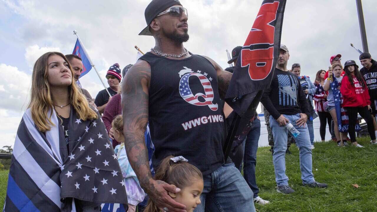 QAnon supporters attend a Trump rally