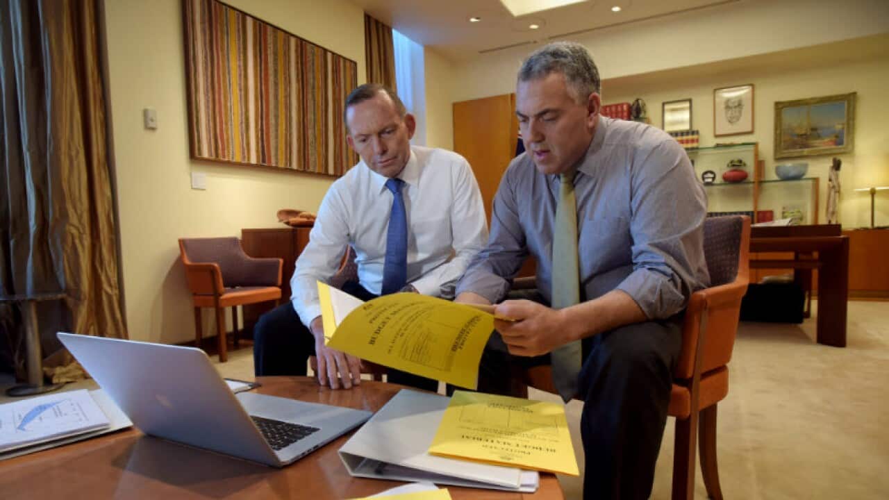 Prime Minister Tony Abbott and Treasurer Joe Hockey pose for pictures as they look through budget papers at Parliament House in Canberra, Tuesday, May 5, 2015. (AAP Image/Lukas Coch)