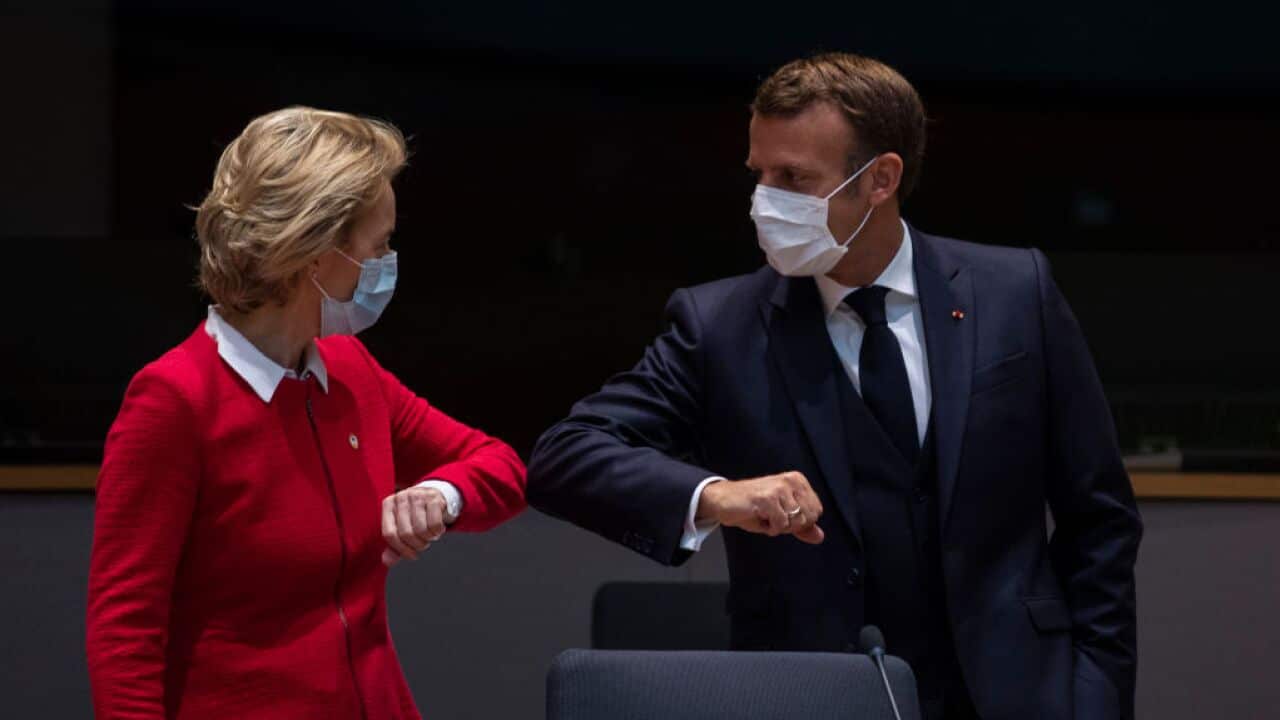 European Commission President Ursula von der Leyen (L) greets French President Emmanuel Macron with an elbow bump during an EU summit