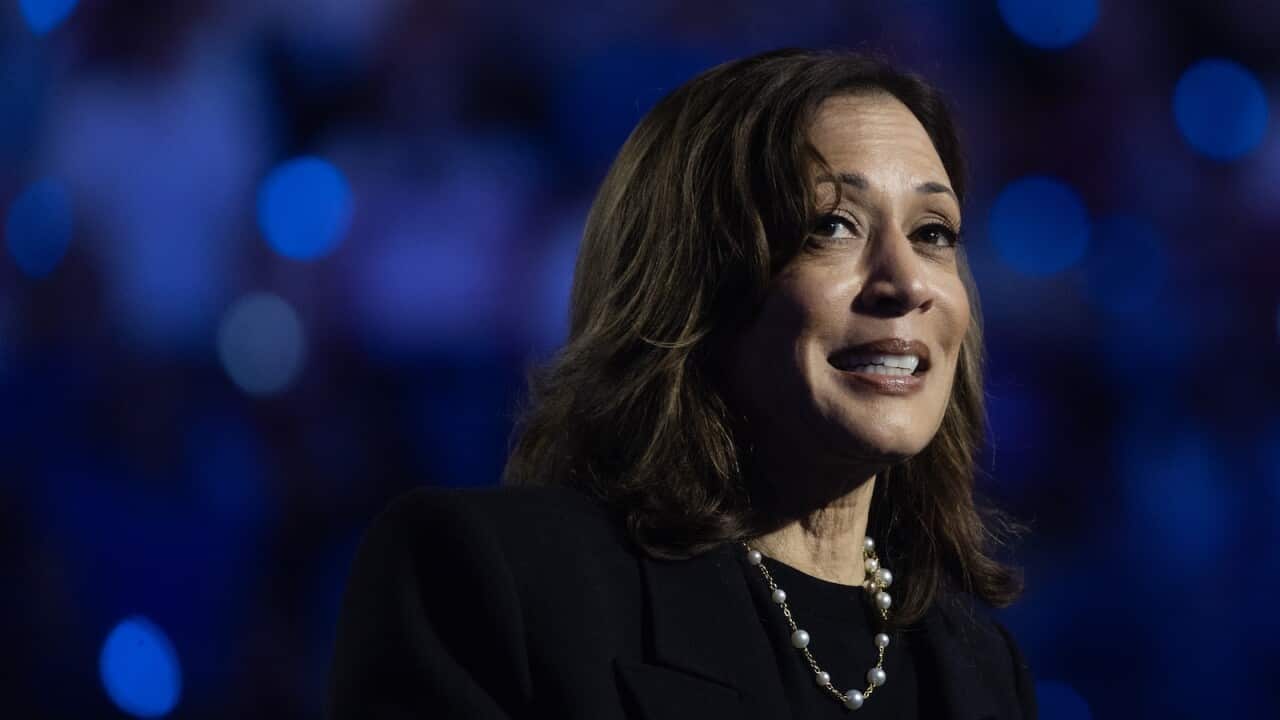 Kamala Harris standing surrounded by blue lights.