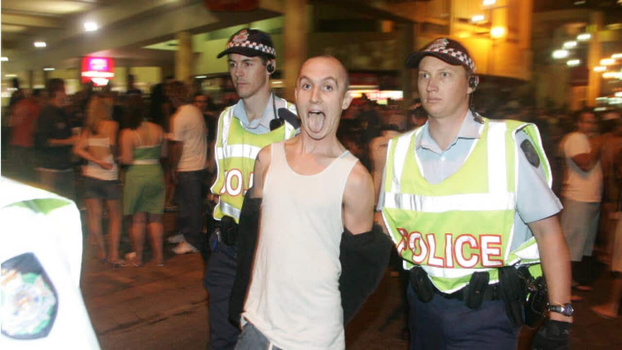 Police arrest a man taking part in the Schoolies Festival