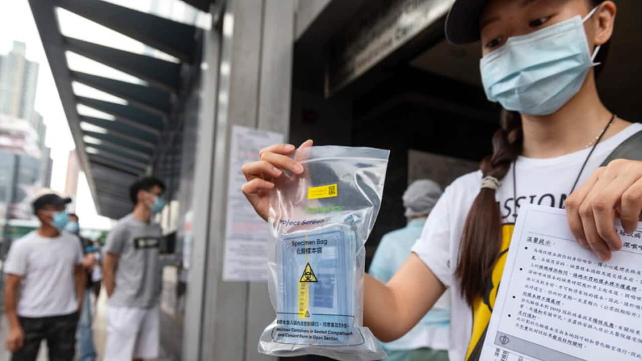 A resident shows a free COVID-19 test kit in Hong Kong
