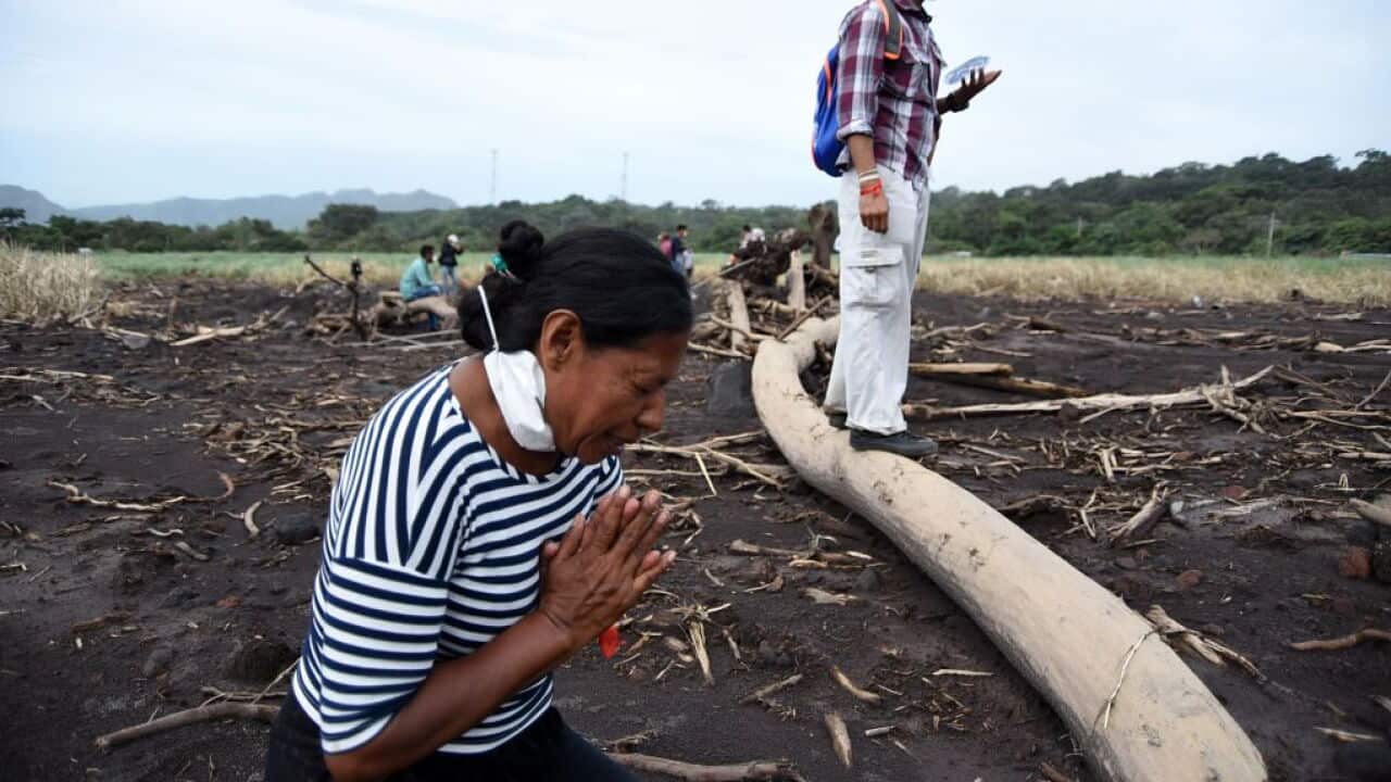 Eufemia Garcia prays before searching for relatives, victims of the Fuego Volcano about 35 km southwest of Guatemala City, on June 8, 2018.